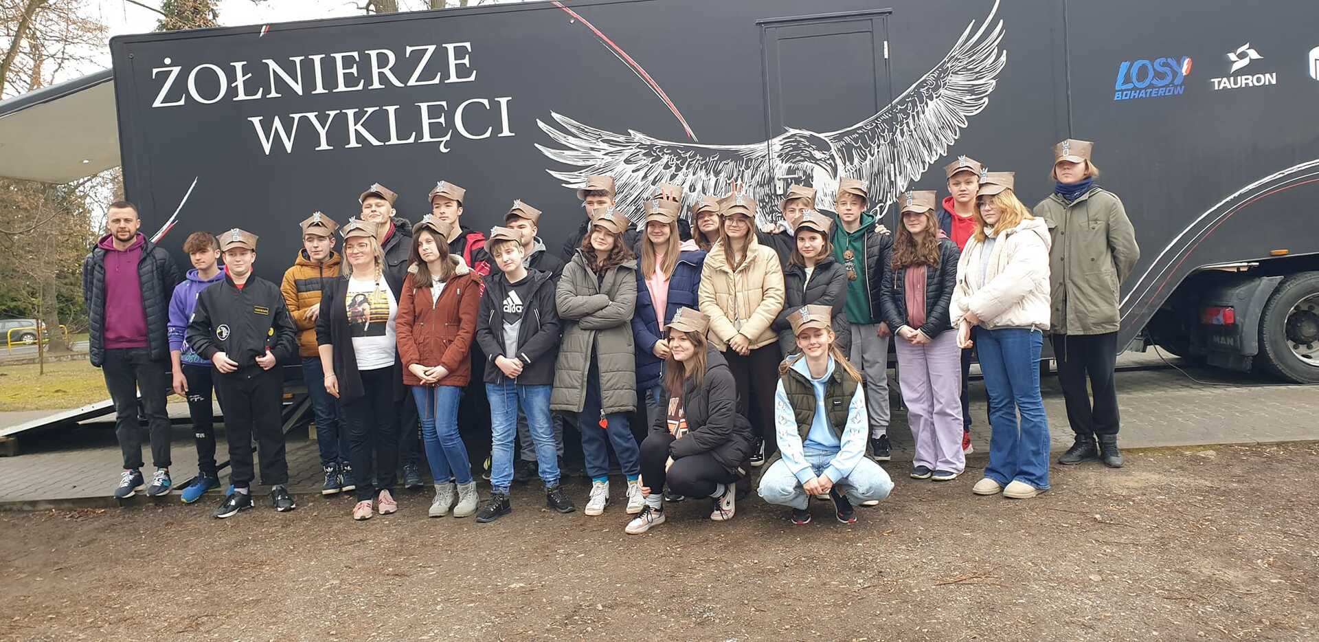 Na zdjęciu znajduje się grupa uczniów klasy VII i VIII na tle napisu " Żołnierze wyklęci"