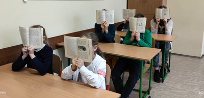 Dzieci trzymające przed sobą książkę.