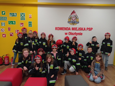 Uczniowie klasy II i III przed logo Jednostki Straży Pożarnej