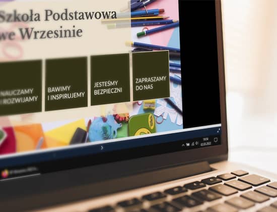 Zdjęcie przedstawiające laptopa z wyświetlaną prezentacją, dotyczącą szkoły.