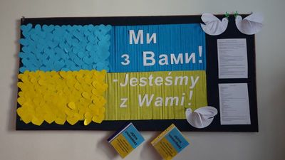 Tablica z flagą Ukrainy wykonaną z serc oraz napis dwujęzyczny: Jesteśmy z Wami.