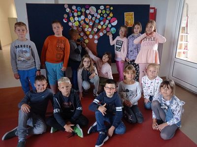 Grupa uczniów z klasy drugiej na tle tablicy z drzewem kropkowym.