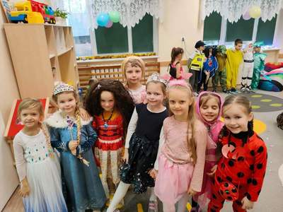 8 dziewczynek w strojach karnawałowych pozujących do wspólnego zdjęcia. 