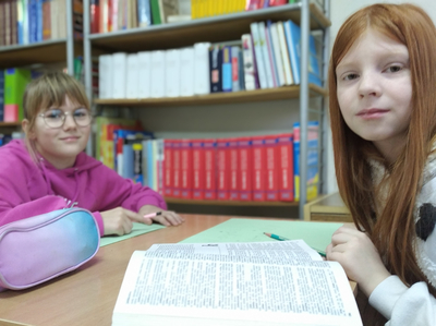 Dwie dziewczynki pracujące przy stole.