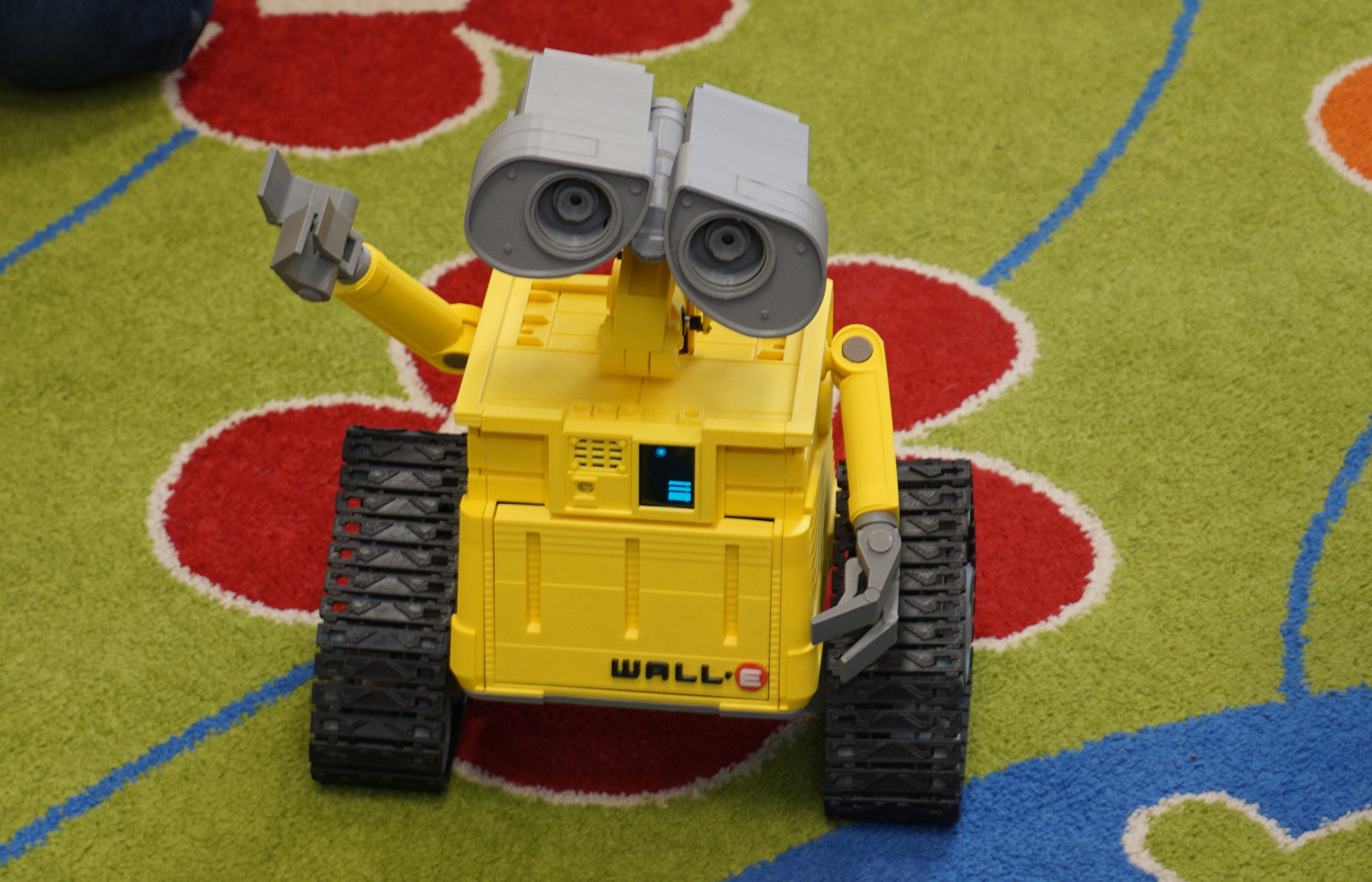 Zdjęcie repliki robota wall-e na dywanie.