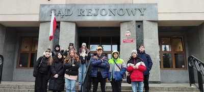 Grupa uczniów na tle budynku Sądu Rejonowego w Olsztynie.