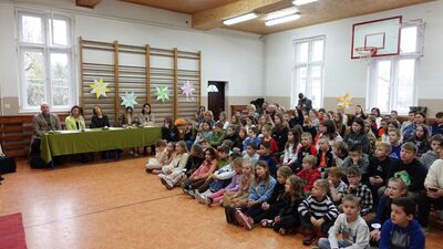 Zdjęcie zgromadzonych uczniów, rodziców, gości i nauczycieli w sali gimnastycznej.