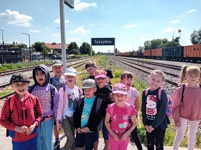 Dzieci czekają na dworcu kolejowym.