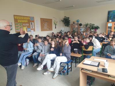Uczniowie klas 4-6 z Prezesem Polskiego Związku Głuchych uczący się języka migowego