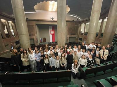 Duża grupa uczniów stojąca na galerii Sali Posiedzeń Sejmu.