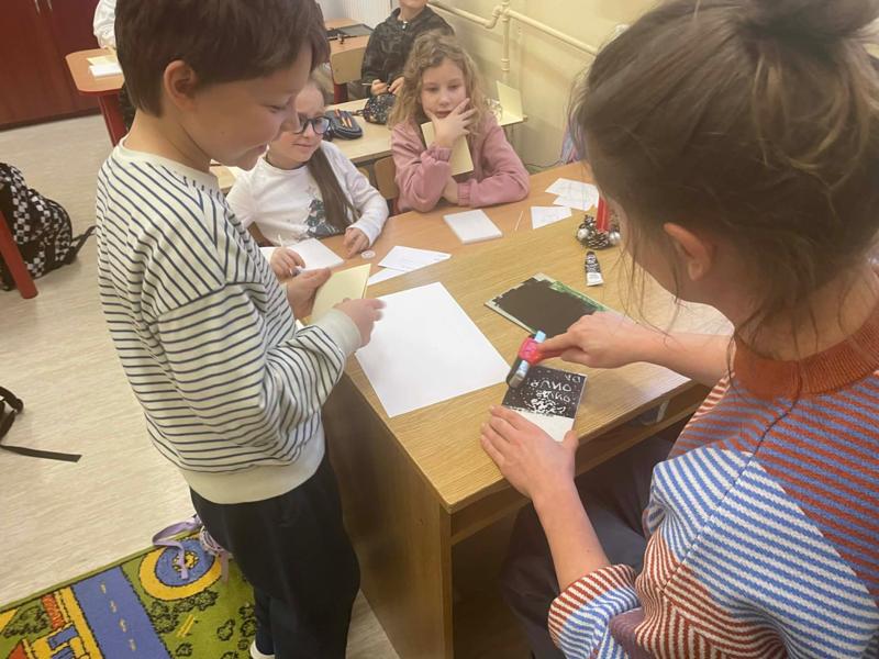 Pani demonstruje dzieciom technikę grafiki