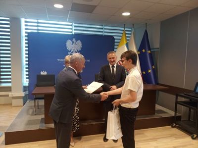 Paweł Zatorski odbiera nagrodę z rąk Kuratora