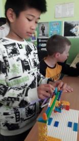 2a buduje z klocków LEGO kolejkę górską.