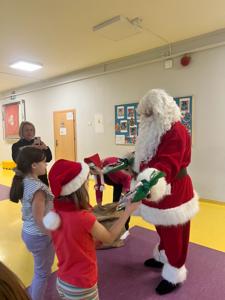 Święty Mikołaj obdarowuje uczniów.