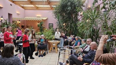 Wolontariusze wręczają kartki seniorom