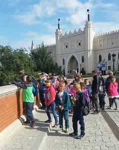 Dzieci słuchają lubelskie legendy opowiadane przez przewodnika.