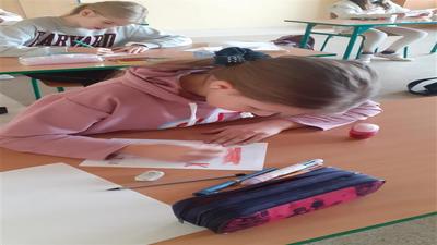 Uczniowie szkoły w trakcie wykonywania kartek dla obrońców granic.