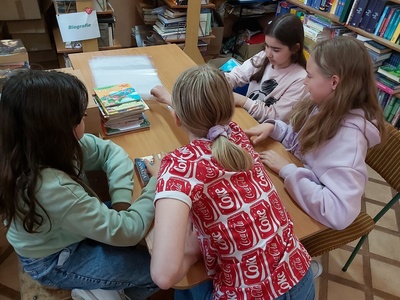 Uczniowie klasy V podczas Tygodnia Bibliotek obkładają książki