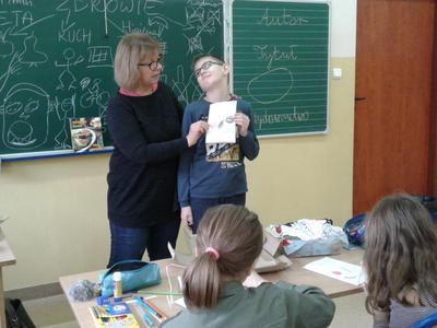 Nauczycielka z uczniem trzymająca kartkę z rysunkiem.
