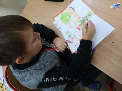 Dziecko rysujące na kartce choinkę