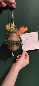 Pisanka Wielkanocna ozdobiona sznurkiem i piórami.