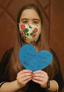 Dziewczynka trzymająca niebieskie serce z napisami pomoc, szacunek, empatia, akceptacja