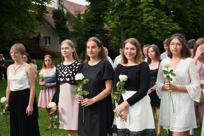 Grupa dziewczyn trzymająca białe róże