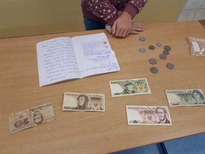 Zdjęcie przedstawia obliczenia pieniężne w zeszycie uczniowskim kwot w zł sprzed denominacji na obecne.