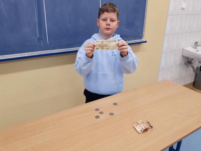 Uczeń prezentujący banknot 50 zł sprzed denominacji.