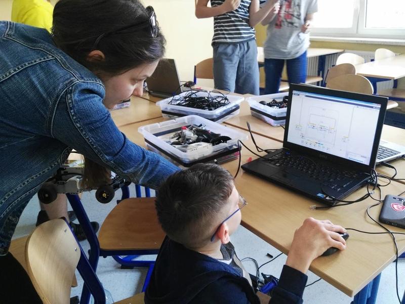 Dziecko przed laptopem z boku nachylona kobieta