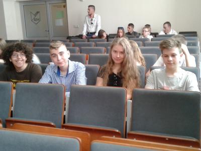 Uczestnicy konkursu siedzący na sali, trzech chłopców i dziewczyna.