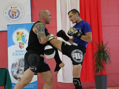 Dwóch sportowców jeden uderza kolanem drugiego