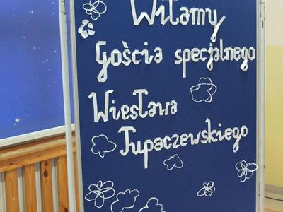 Tablica z białym napisem Witamy Gościa specjalnego Wiesława Tupaczewskiego.