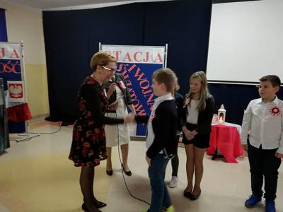 Dyrektor szkoły podający rękę dziecku w ramach podziękowania.