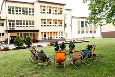uczniowie czytają książki dzieciom