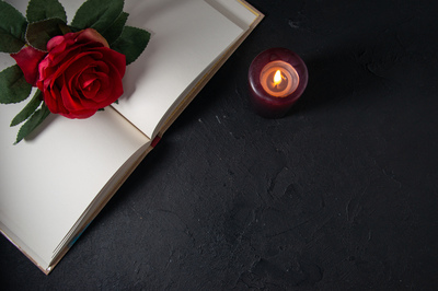 topviewopenbookwithcandleredflowerdarkwall.jpg[small]