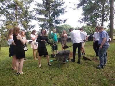 Ceremonia sadzenia pamiątkowego drzewka absolwenta przez uczniów klasy III gimnazjum.