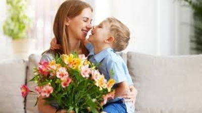 Mama z bukietem kwiatów i swoim synkiem, którego trzyma na kolanach
