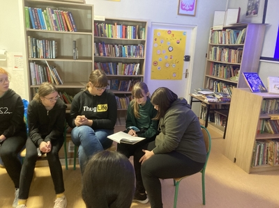 Wspólne czytanie grupy uczennic z klasy 8b w bibliotece 