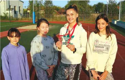 Paulina Paluch nie zapomina o szkole. Na zdjęciu prezentuje medale Mistrzostw Polski w otoczeniu
najmłodszych adeptek lekkiej atletyki ZSP Jedlińsk.
