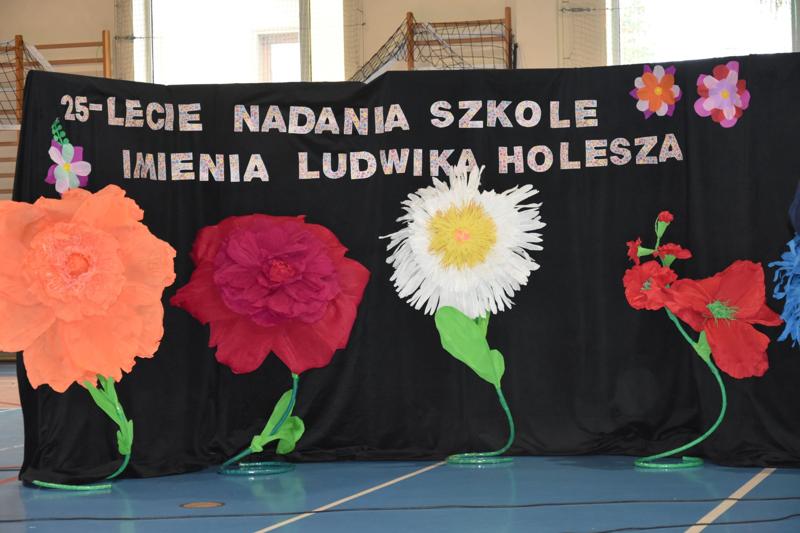 Dekoracja kwiaty i napis 25 lecie nadania szkole imienia Ludwika Holesza