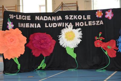 Dekoracja kwiaty i napis 25 lecie nadania szkole imienia Ludwika Holesza