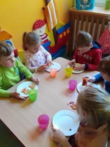 Dzieci podczas jedzenia pizzy.