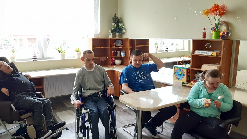 Na zdjęciu można zauważyć grupę trzech chłopców i jednej dziewczynki łapiących bańki mydlane [800x450]