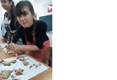 Gabrysia dekoruje upieczone pierniczki lukrem i kolorowymi cukierkami