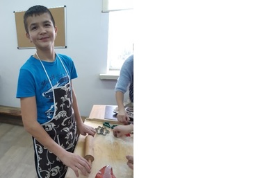 Kewin stoi przy stolnicy z wałkiem w rękach, już przygotowany do pracy. 