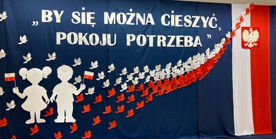 Dekoracja - postacie dzieci na tle biało- czerwonym .