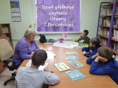 Klasa III au na zajęciach w bibliotece. Pani bibliotekarka czyta uczniom książkę „Szewczyk Dratewka”.