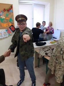 Uczeń Filip przebrany w mundur. W tle chłopcy z Panią Beatą ćwiczą „Jak pracuje mózg”.