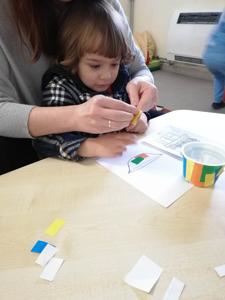 Chłopczyk z Pani pomocą wykleja miseczkę kotkowi.